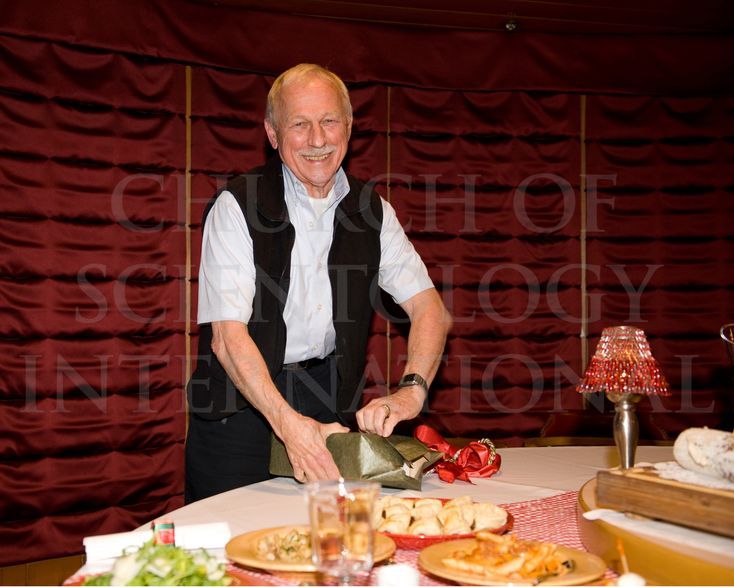 Ron Miscavige opens a present given to him by his son, Mr. David Miscavige, at his 74th birthday dinner in 2010.